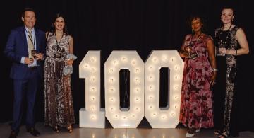 Gala Attendees with Lighted 100 Sign